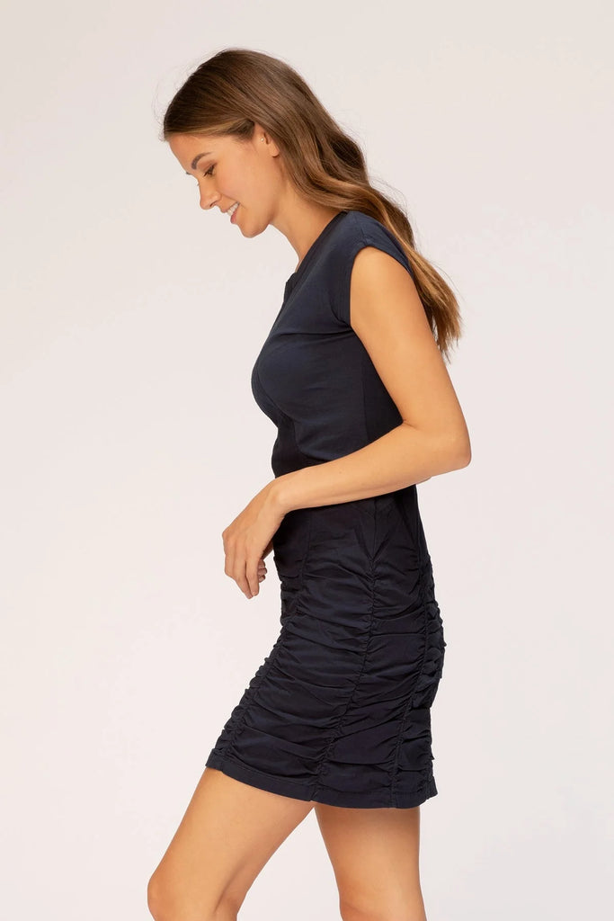 This stretch poplin dress features short sleeves, ruching on skirt, jersey inserts in the bodice for an impeccable fit, and style lines for added structure.