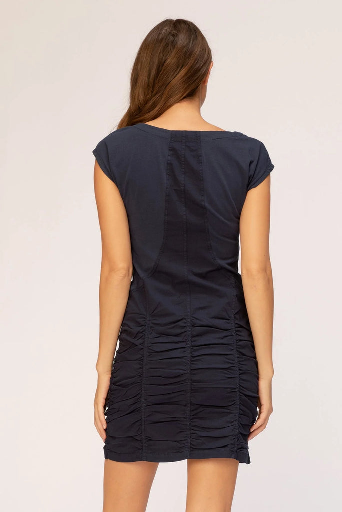 This stretch poplin dress features short sleeves, ruching on skirt, jersey inserts in the bodice for an impeccable fit, and style lines for added structure.