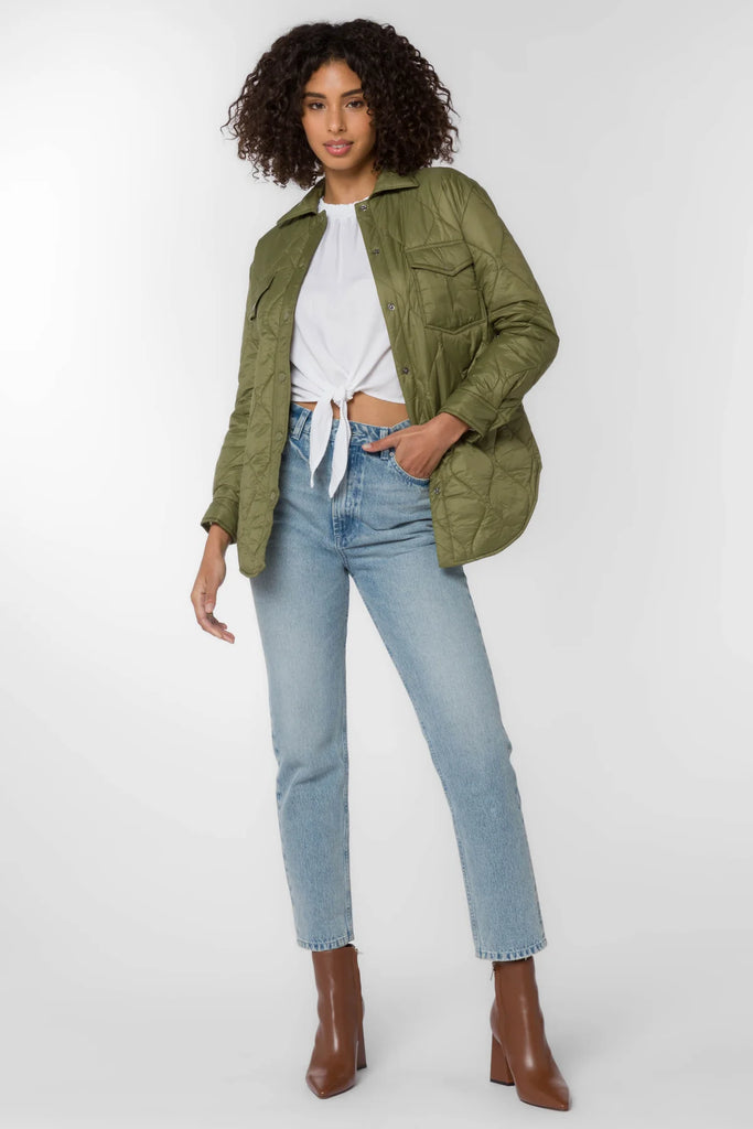 The Eleanor light weight puffer in olive color is crafted from a nylon quilted fabric. It features chest pockets, side seam pockets, snap closure and a dolphin hem for a flattering fit.
