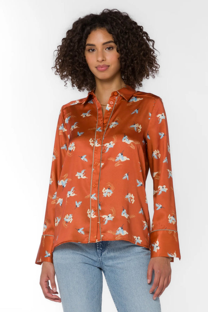 Constructed with long sleeves, a button-up front, and a back yoke, The Liza Rust Blue Cranes Print Shirt is a stylish choice for any formal or casual occasion.