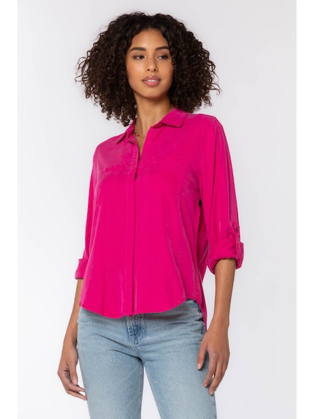 The Riley collared button-down shirt in Bright Fuchsia features rolled tab sleeves, double chest pockets, a split back tail, and a hi-lo hem. This shirt is a perfect staple to any wardrobe. 