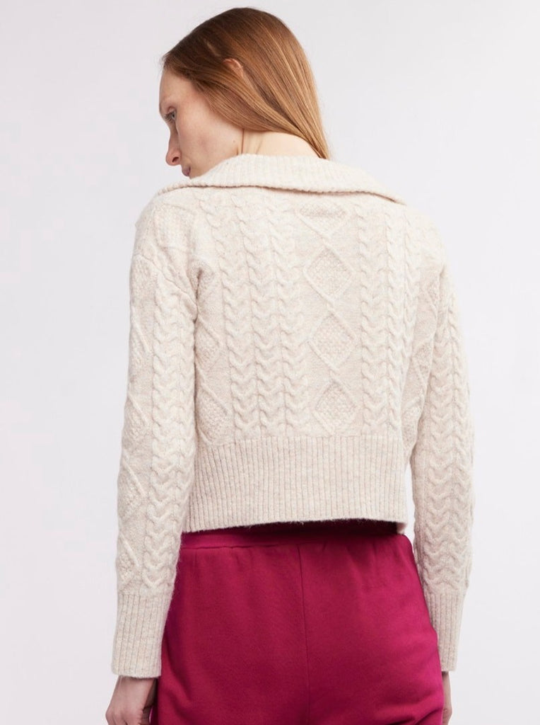 This season, wrap yourself with warmth and style in our cozy Malia Open Collar Sweater in birch, a beautiful neutral color. With a beautifully textured cable knit and timeless open collar, you'll look put-together even when it’s cold outside! Cut in a wedge shape, distinguished by its wide fit at the shoulders that gently tapers towards the hem.