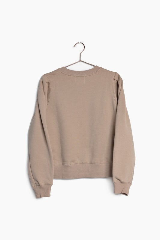 The Simone sweater in coffee color. The Simone Sweater has a slightly boxy fit with a front seam detail and a shoulder pleat for added fullness. It also features a ribbed hem and crew neckline. Fabric Content: 100% Cotton