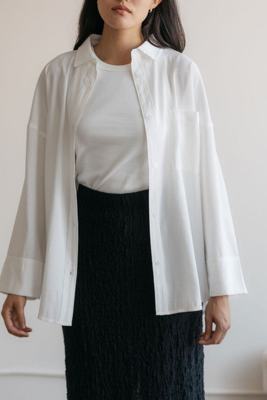 The Lila button up shirt in white. Cut in an oversized shape, it's detailed with a single front patch pocket, wide hem sleeves with elongated sleeve tabs and a pleated back. Crafted from a soft, cupro fabric for that cool feeling. 86% Rayon, 14% Polyester