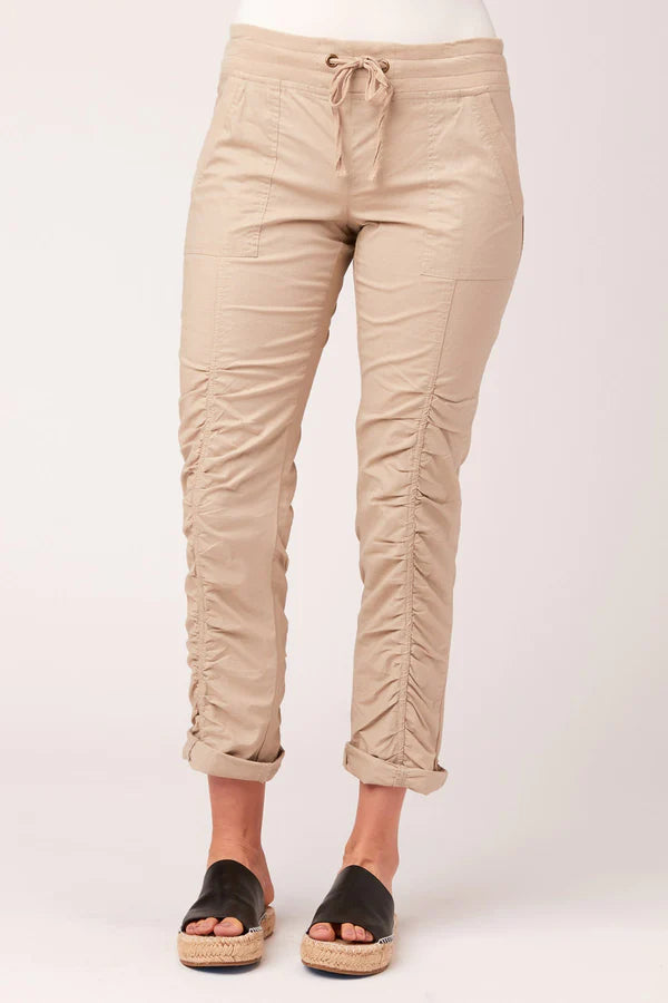 Women's Jules Pant in sand. Simply classic. This pant features drawstring waistband, two front pockets, rouching on pant leg, style lines for added structure, and drawstring at hem. Fabric Content: Stretch poplin body - 96/4 Cotton/Spandex