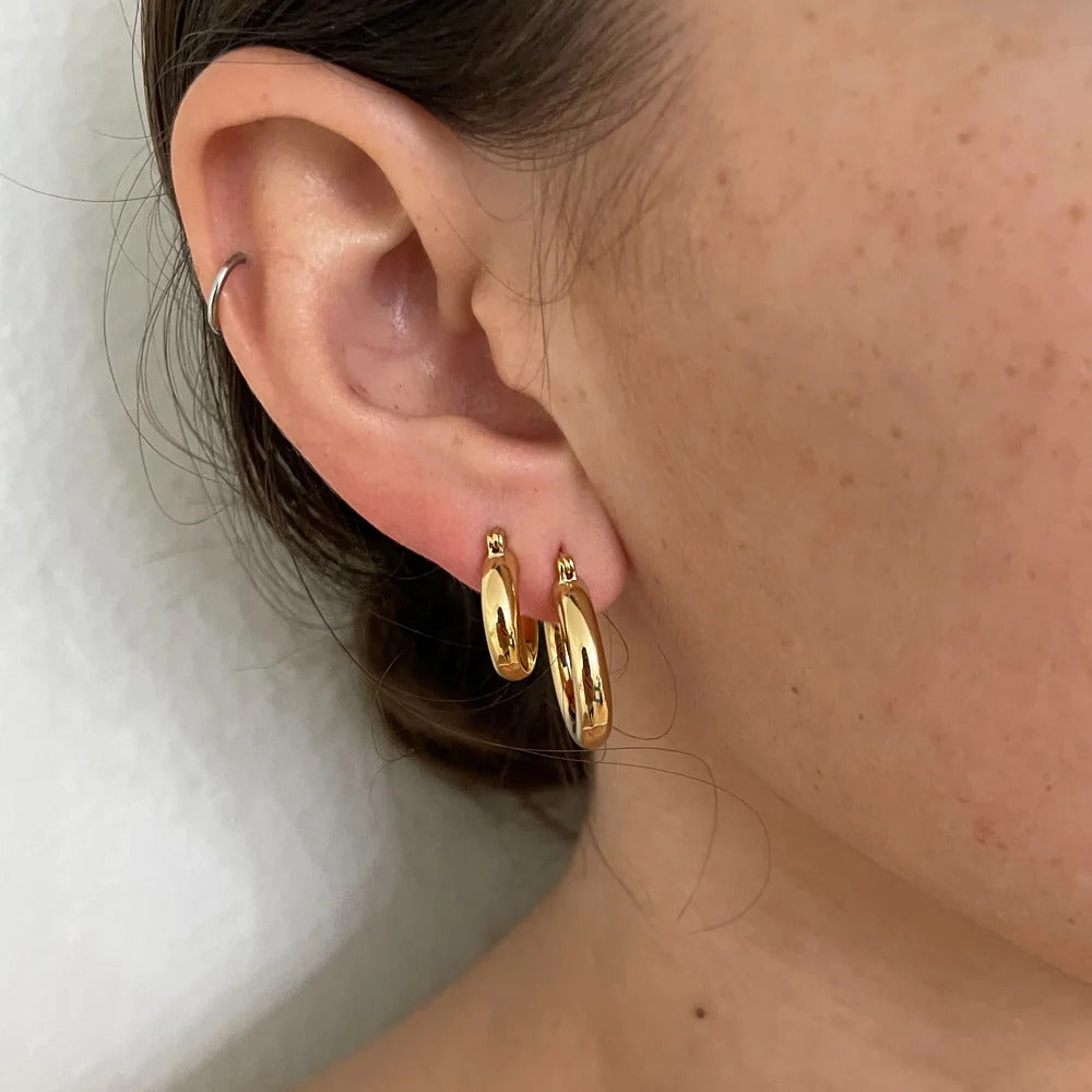 Our Best-selling silhouette now in a midi hoop! These thick gold hoops are perfect for your ear party. 20mm Earrings are of Gigi Midi Hoop and Baby Gigi Hoop