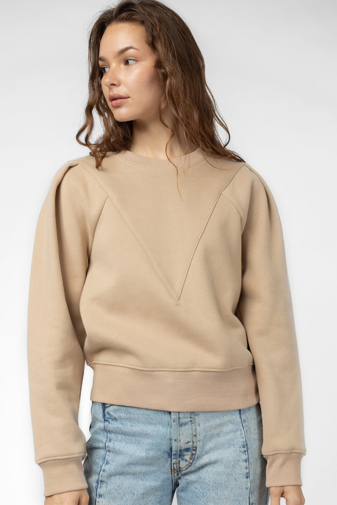 The Simone sweater in coffee color. The Simone Sweater has a slightly boxy fit with a front seam detail and a shoulder pleat for added fullness. It also features a ribbed hem and crew neckline. Fabric Content: 100% Cotton