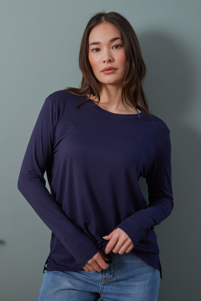 Suzanne Tee in Navy. Your essential long sleeve tee! The Suzanne features a loose, relaxed fit with a crew neck and side split hem. A year-round necessity, the Suzanne is the perfect lightweight long sleeve tee.