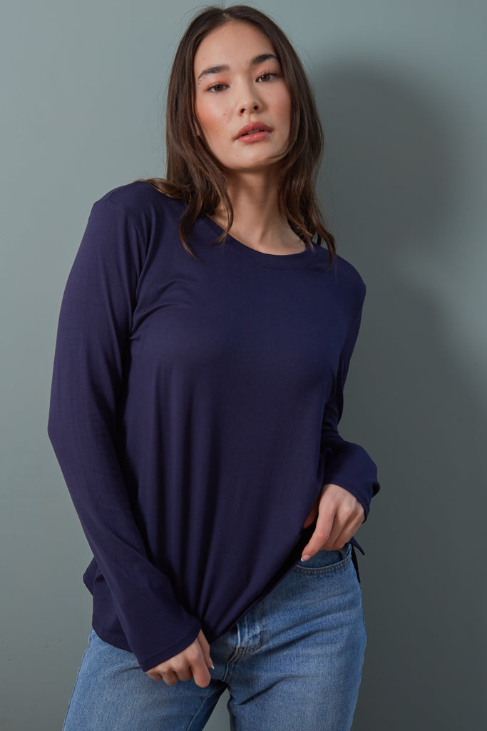 Suzanne Tee in Navy. Your essential long sleeve tee! The Suzanne features a loose, relaxed fit with a crew neck and side split hem. A year-round necessity, the Suzanne is the perfect lightweight long sleeve tee.