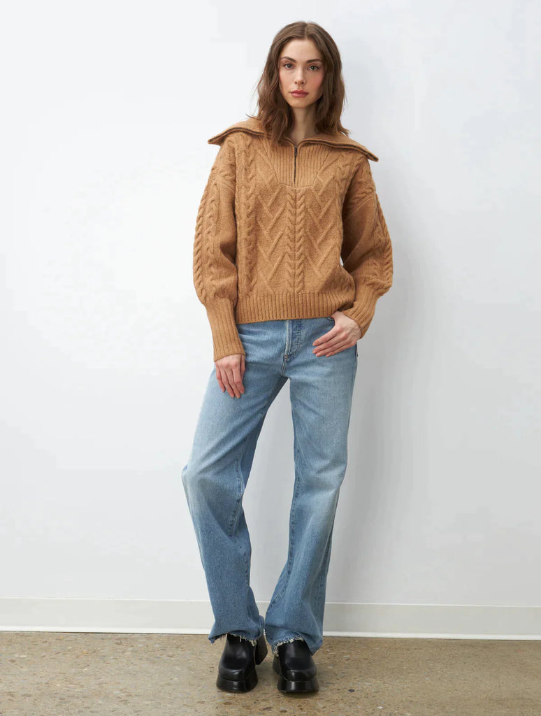 A must-have staple sweater, this cozy-chic caramel color pullover features a relaxed silhouette with a quarter-zip neckline, cable stitching, and rib knit trim. Layer over your favorite top as a sweater jacket. You'll be wearing it all season long with jeans, leggings, and trousers.  