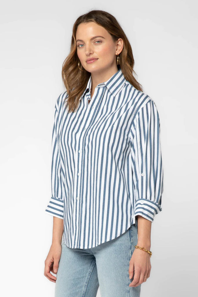 The Suri Shirt is a stylish wardrobe staple. It features long cuffed sleeves, a button-up front, a high-low hem, a back yoke, and a collar for a professional and polished look. Elevate your casual look with this classic design.