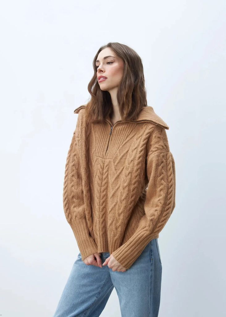 A must-have staple sweater, this cozy-chic caramel color pullover features a relaxed silhouette with a quarter-zip neckline, cable stitching, and rib knit trim. Layer over your favorite top as a sweater jacket. You'll be wearing it all season long with jeans, leggings, and trousers.  