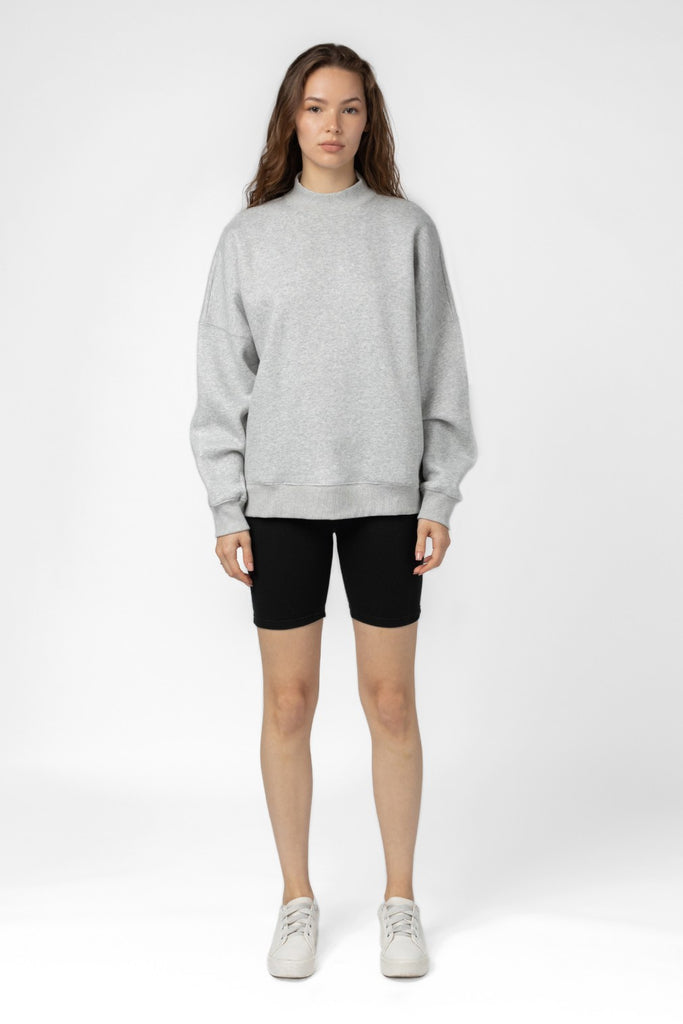 Women's oversize sweater in heather grey. Made with the softest fabric, this slub woven sweatshirt features long, puff sleeves, a high neck and side pockets. Fabric Content: 50% Polyester 50% Cotton