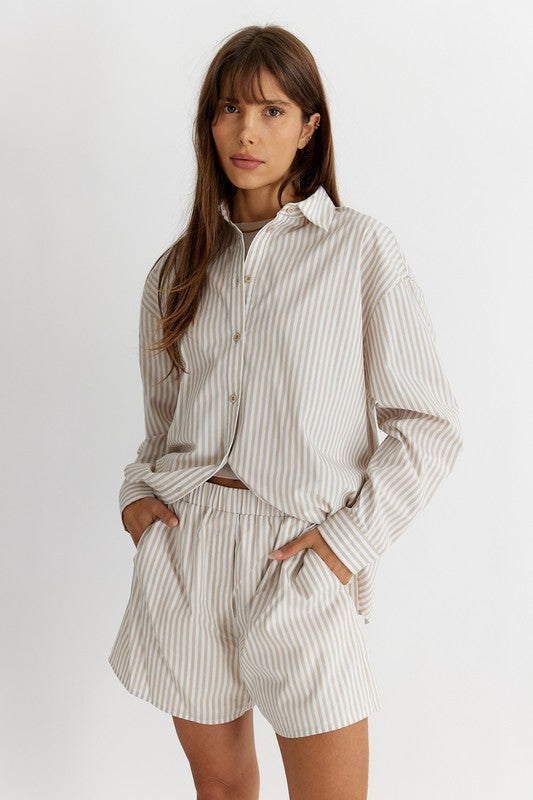 Women's Striped Poplin Cotton Shirt in Biege. The Emry Top is a striped cotton poplin shirt crafted in an oversized silhouette. It's detailed with a pointed collar and front button closure. A must-have this season to layer with your favorite denim jeans, unbuttoned over a simple tank top. Fabric Content: 100% Cotton
