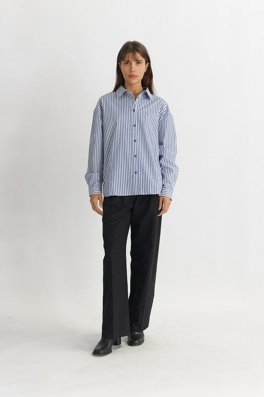 Women's Striped Poplin Cotton Shirt in Blue. The Emry Top is a striped cotton poplin shirt crafted in an oversized silhouette. It's detailed with a pointed collar and front button closure. A must-have this season to layer with your favorite denim jeans, unbuttoned over a simple tank top. Fabric Content: 100% Cotton