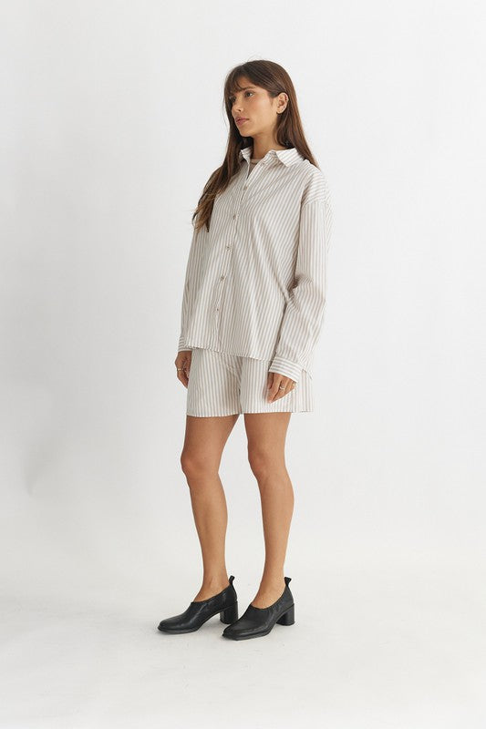 Women's Striped Poplin Cotton Shirt in Biege. The Emry Top is a striped cotton poplin shirt crafted in an oversized silhouette. It's detailed with a pointed collar and front button closure. A must-have this season to layer with your favorite denim jeans, unbuttoned over a simple tank top. Fabric Content: 100% Cotton