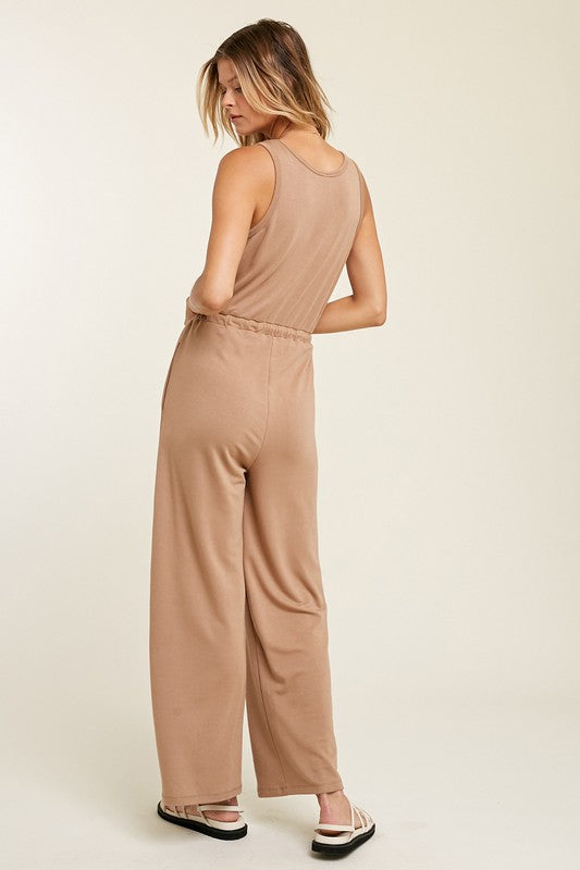 French Terry Knit Jumpsuit with Drawstring in Mocha color. This ultra soft French knit jumpsuit is a relaxed fit with a drawstring cord to make a sporty look. Fabric Content: 63% POLYESTER, 33% RAYON, 4% SPANDEX