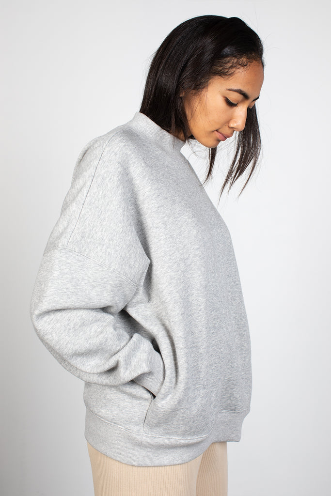 Women's oversize sweater in heather grey. Made with the softest fabric, this slub woven sweatshirt features long, puff sleeves, a high neck and side pockets. Fabric Content: 50% Polyester 50% Cotton